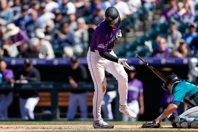 Apr 21, 2024; Denver, Colorado, USA; Colorado Rockies center fielder Brenton Doyle (9) reacts after being hit by a pitch in the sixth inning against the Seattle Mariners at Coors Field. Mandatory Credit: Isaiah J. Downing-USA TODAY Sports