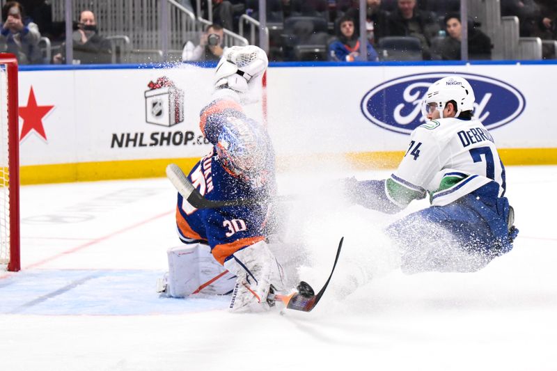 Dec 19, 2025; Elmont, New York, USA; New York Islanders goaltender Ilya Sorokin (30) makes a save against Vancouver Canucks left wing Jake Debrusk (74) during the third period at UBS Arena. Mandatory Credit: John Jones-Imagn Images
