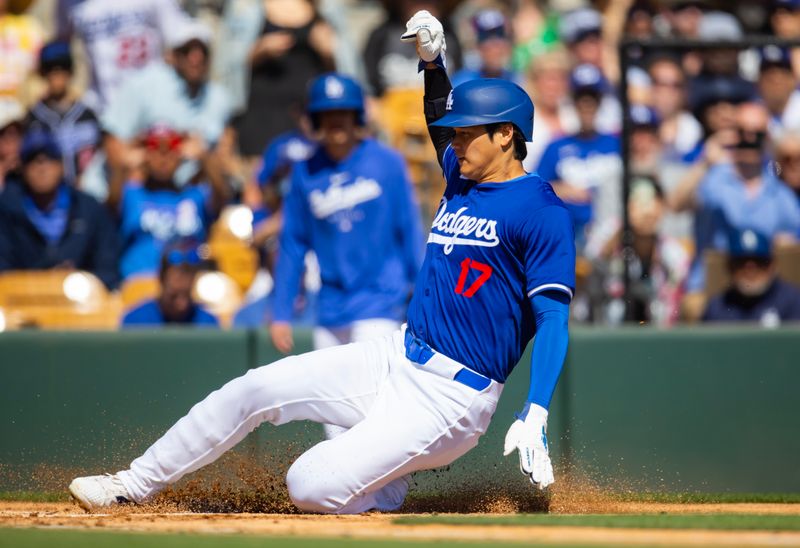 Mar 3, 2024; Phoenix, Arizona, USA; Los Angeles Dodgers designated hitter Shohei Ohtani slides into home plate to score a run against the Colorado Rockies during a spring training game at Camelback Ranch-Glendale. Mandatory Credit: Mark J. Rebilas-USA TODAY Sports