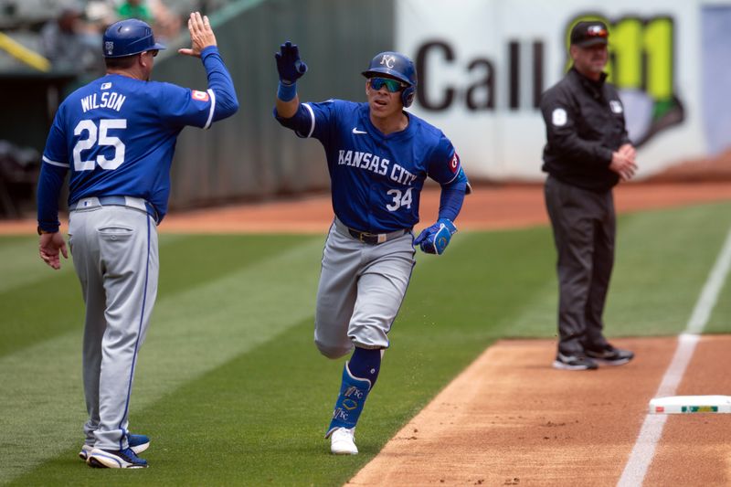 Jun 20, 2024; Oakland, California, USA; Kansas City Royals designated hitter Freddy Fermin (34) gets a high five from third base coach Vance Wilson (25) after hitting a solo home run against the Oakland Athletics during the second inning at Oakland-Alameda County Coliseum. Mandatory Credit: D. Ross Cameron-USA TODAY Sports