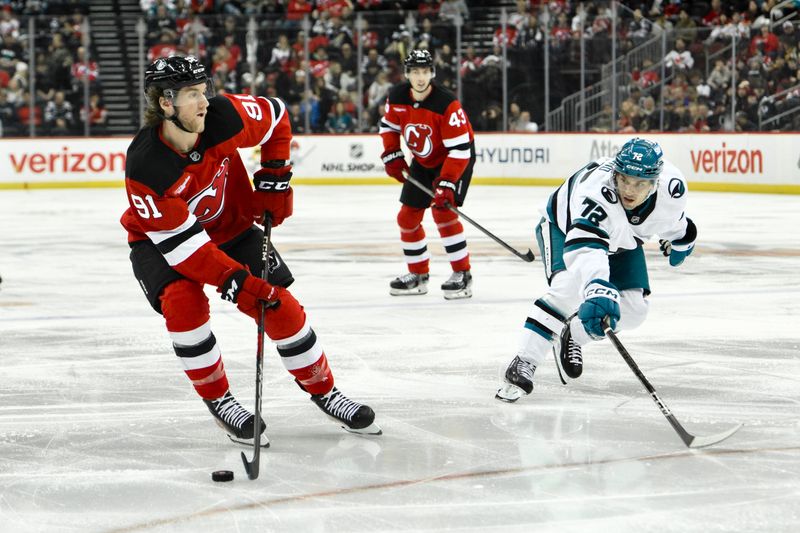 Nov 10, 2024; Newark, New Jersey, USA; New Jersey Devils center Dawson Mercer (91) skates with the puck against San Jose Sharks left wing William Eklund (72) during the second period at Prudential Center. Mandatory Credit: John Jones-Imagn Images