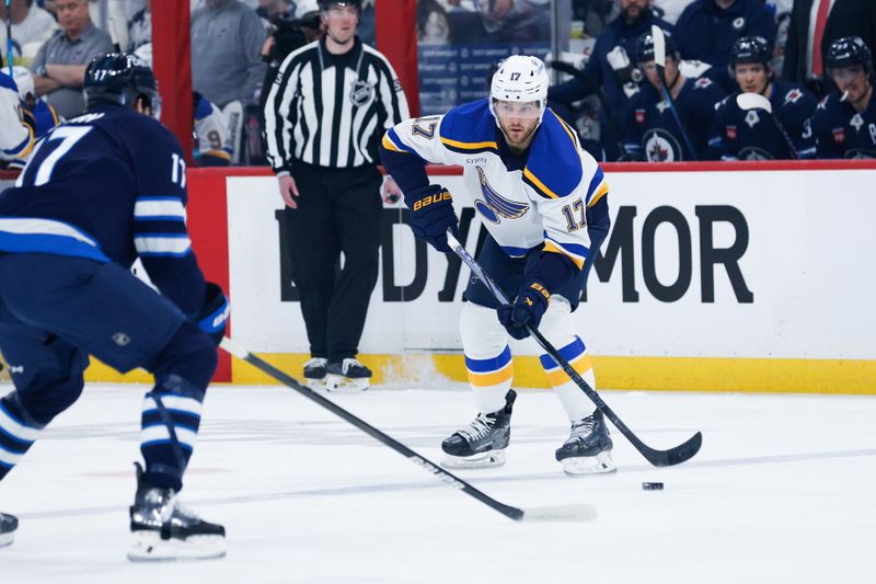 Apr 30, 2025; Winnipeg, Manitoba, CAN; St. Louis Blues defenseman Cam Fowler (17) looks to make a play against Winnipeg Jets forward Adam Lowry (17) during the first period in game five of the first round of the 2025 Stanley Cup Playoffs at Canada Life Centre. Mandatory Credit: Terrence Lee-Imagn Images