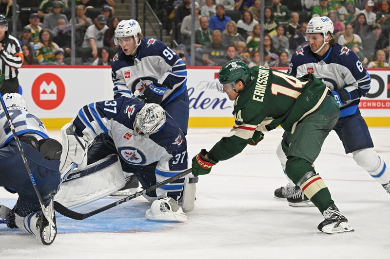 Sep 27, 2024; Saint Paul, Minnesota, USA;  Minnesota Wild forward Joel Eriksson Ek (14) puts a rebound past Winnipeg Jets goalie Connor Hellebuyck (37) for a goal during the second period at Xcel Energy Center. Mandatory Credit: Nick Wosika-Imagn Images

