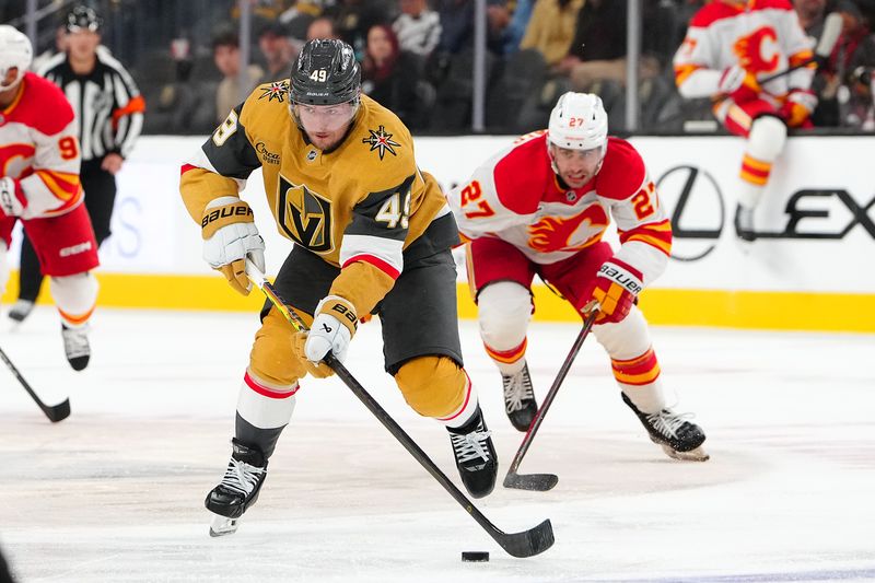 Oct 18, 2025; Las Vegas, Nevada, USA; Vegas Golden Knights left wing Ivan Barbashev (49) controls the puck ahead of Calgary Flames right wing Matt Coronato (27) during the second period at T-Mobile Arena. Mandatory Credit: Stephen R. Sylvanie-Imagn Images