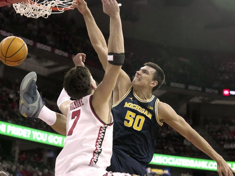 Dec 3, 2024; Madison, Wisconsin, USA; Michigan center Vladislav Goldin (50) dunks on Wisconsin forward Carter Gilmore (7) during the first half of their game Tuesday, December 3, 2024 at the Kohl Center in Madison, Wisconsin. Mandatory Credit: Mark Hoffman/USA TODAY Network via Imagn Images 