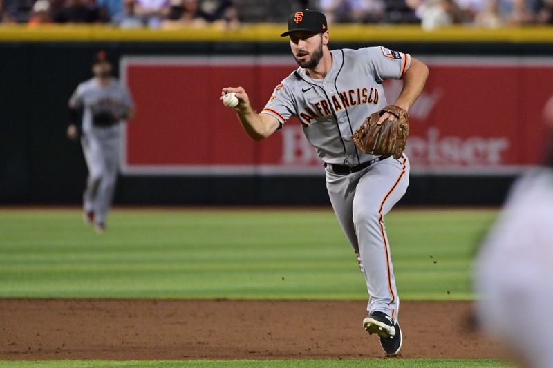 Sep 19, 2023; Phoenix, Arizona, USA; San Francisco Giants shortstop Paul DeJong (18) fields a ball in the eighth inning against the Arizona Diamondbacks at Chase Field. Mandatory Credit: Matt Kartozian-USA TODAY Sports