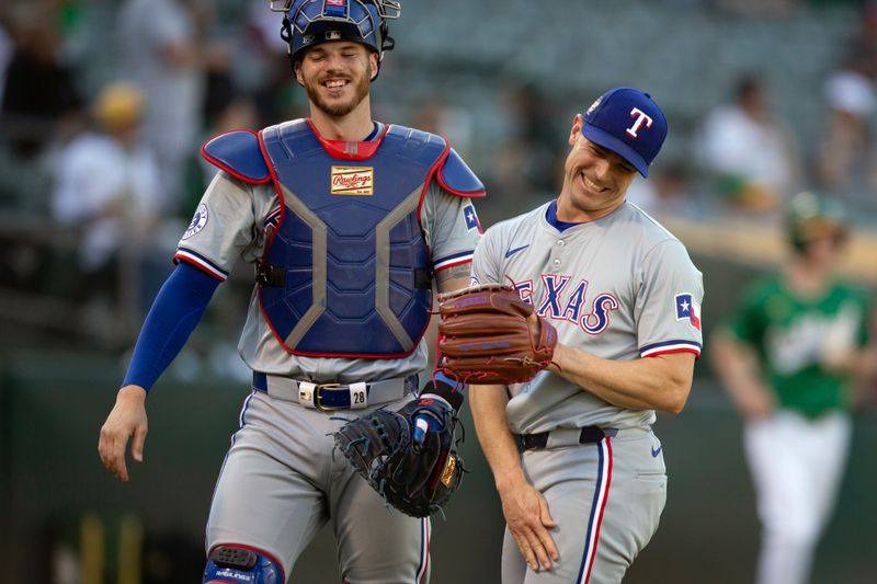 May 8, 2024; Oakland, California, USA; Texas Rangers catcher Jonah Heim (28) and pitcher David Robertson (37) share a laugh after striking out the side against the Oakland Athletics during the seventh inning at Oakland-Alameda County Coliseum. Mandatory Credit: D. Ross Cameron-USA TODAY Sports