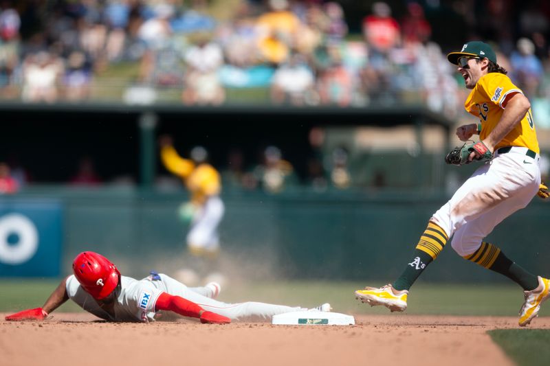 May 25, 2025; West Sacramento, California, USA; Athletics shortstop Jacob Wilson (5) celebrates after tagging out Philadelphia Phillies pinch runner Johan Rojas (23) as he attempts to steal second base during the ninth inning at Sutter Health Park. Mandatory Credit: D. Ross Cameron-Imagn Images