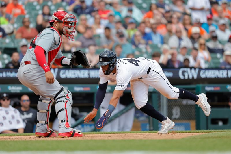 May 1, 2024; Detroit, Michigan, USA; Detroit Tigers right fielder Wenceel Perez (46) dives in safe at home in the eighth inning in front of St. Louis Cardinals catcher Willson Contreras (40) at Comerica Park. Mandatory Credit: Rick Osentoski-USA TODAY Sports
