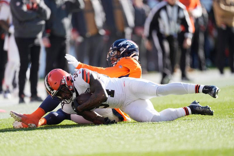 Cleveland Browns running back Jerome Ford (34) is tackled by Denver Broncos safety P.J. Locke (6) in the first half of an NFL football game Sunday, Nov. 26, 2023, in Denver. (AP Photo/David Zalubowski)