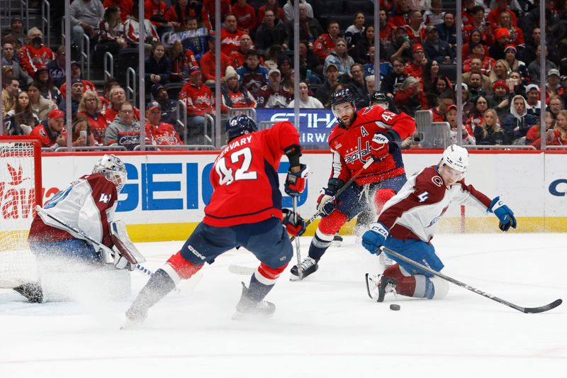 Feb 13, 2024; Washington, District of Columbia, USA; Washington Capitals defenseman Martin Fehervary (42) and Colorado Avalanche defenseman Bowen Byram (4) battles for the puck in front of Avalanche goaltender Alexandar Georgiev (40) as Capitals right wing Tom Wilson (43) looks on in the second period at Capital One Arena. Mandatory Credit: Geoff Burke-USA TODAY Sports