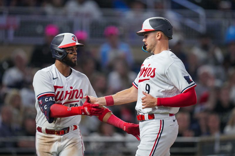 Sep 27, 2023; Minneapolis, Minnesota, USA; Minnesota Twins center fielder Willi Castro (50) congratulates left fielder Trevor Larnach (9) after scoring against the Oakland Athletics in the eighth inning at Target Field. Mandatory Credit: Brad Rempel-USA TODAY Sports