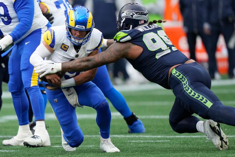 Los Angeles Rams quarterback Matthew Stafford, left, is tackled by Seattle Seahawks defensive end Leonard Williams during the first half of an NFL football game in Seattle, Sunday, Nov. 3, 2024. (AP Photo/Stephen Brashear)