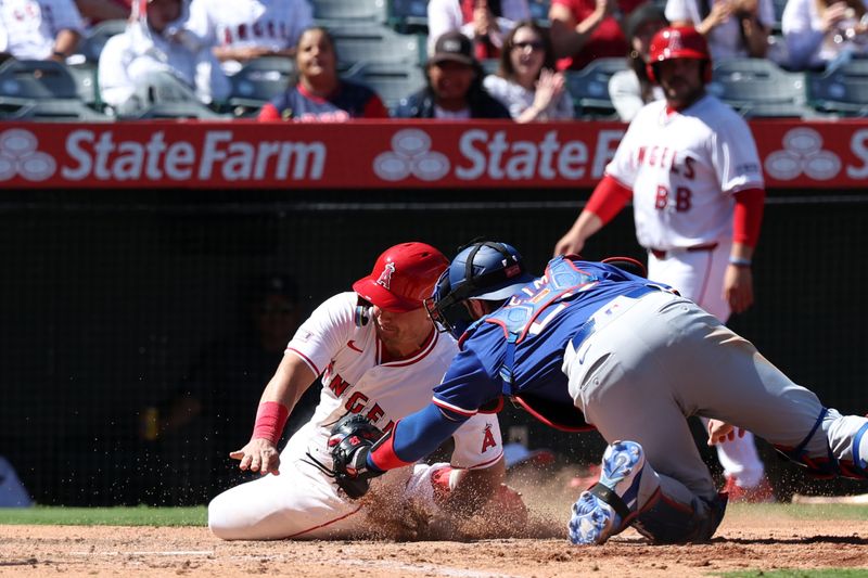 Sep 29, 2024; Anaheim, California, USA;  Texas Rangers catcher Jonah Heim (28) tags out Los Angeles Angels catcher Matt Thaiss (21) at home plate during the seventh inning at Angel Stadium. Mandatory Credit: Kiyoshi Mio-Imagn Images