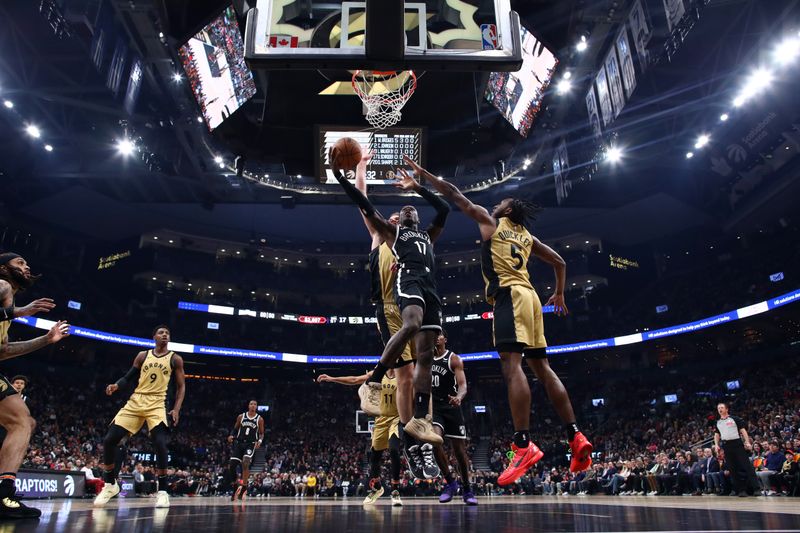 TORONTO, CANADA - FEBRUARY 22: Dennis Schroder #17 of the Brooklyn Nets drives to the net against Immanuel Quickley #5 of the Toronto Raptors in the first half of their NBA game at Scotiabank Arena on February 22, 2024 in Toronto, Canada. NOTE TO USER: User expressly acknowledges and agrees that, by downloading and or using this photograph, User is consenting to the terms and conditions of the Getty Images License Agreement. (Photo by Cole Burston/Getty Images)