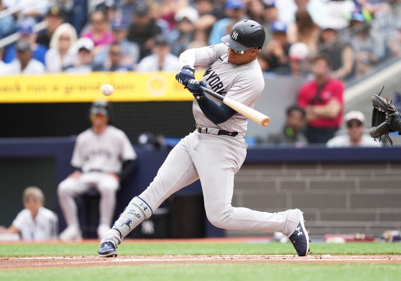 Jun 30, 2024; Toronto, Ontario, CAN; New York Yankees right fielder Juan Soto (22) hits a single against the Toronto Blue Jays during the first inning at Rogers Centre. Mandatory Credit: Nick Turchiaro-USA TODAY Sports