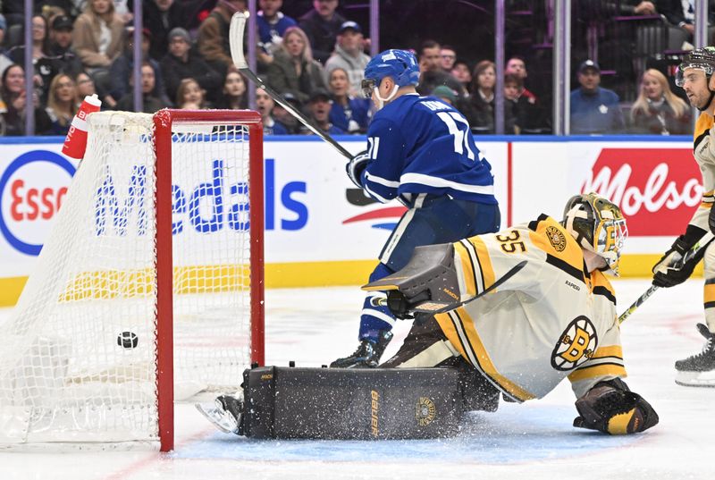 Dec 2, 2023; Toronto, Ontario, CAN; Toronto Maple Leafs forward Max Domi (11) scores a goal past Boston Bruins goalie Linus Ullmark (35) in the third period at Scotiabank Arena. Mandatory Credit: Dan Hamilton-USA TODAY Sports