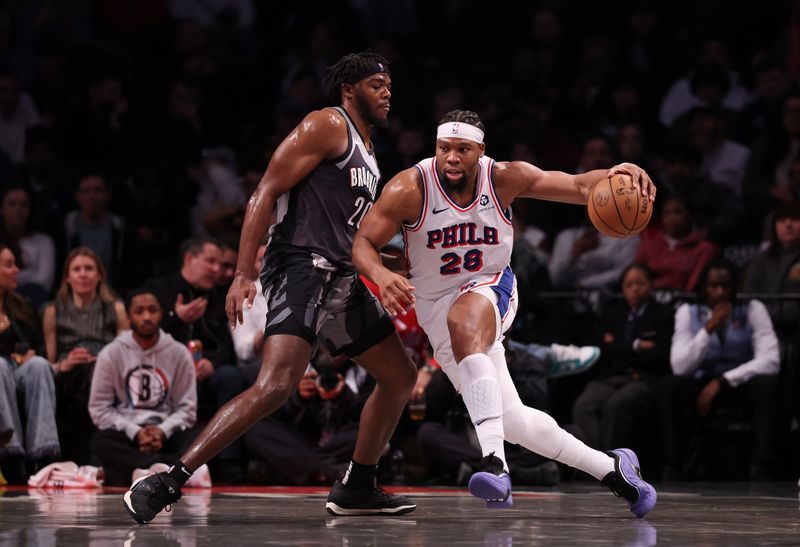 NEW YORK, NEW YORK - FEBRUARY 12:  Guerschon Yabusele #28 of the Philadelphia 76ers drives against Day'Ron Sharpe #20 of the Brooklyn Nets during their game at Barclays Center on February 12, 2025 in New York City. User expressly acknowledges and agrees that, by downloading and or using this photograph, User is consenting to the terms and conditions of the Getty Images License Agreement.   (Photo by Al Bello/Getty Images)