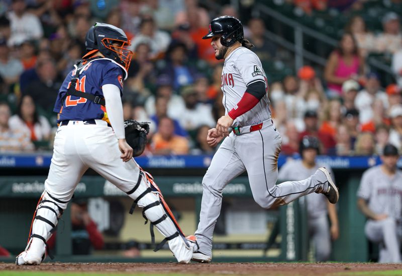 Sep 8, 2024; Houston, Texas, USA; Arizona Diamondbacks third baseman Eugenio Suarez (28) scores a run past Houston Astros catcher Yainer Diaz (21) during the seventh inning at Minute Maid Park. Mandatory Credit: Troy Taormina-Imagn Images