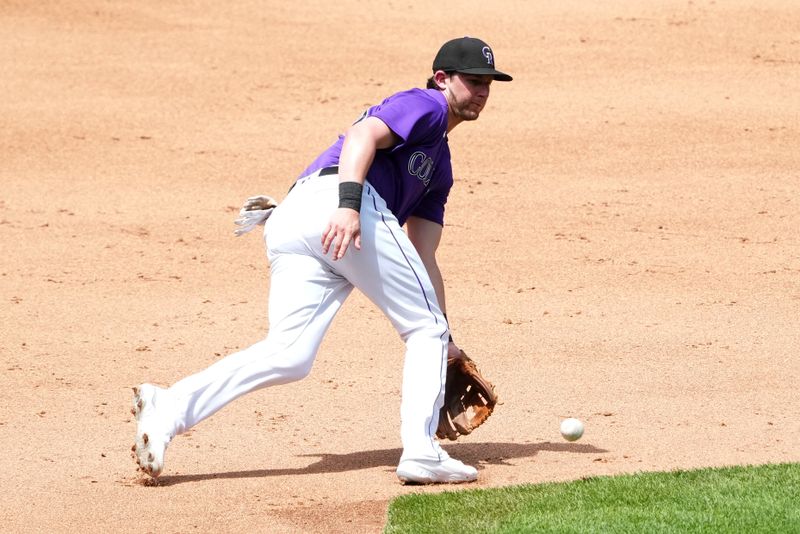 Jul 30, 2023; Denver, Colorado, USA; Colorado Rockies third baseman Ryan McMahon (24) fields the ball in the fifth inning against the Oakland Athletics  at Coors Field. Mandatory Credit: Ron Chenoy-USA TODAY Sports