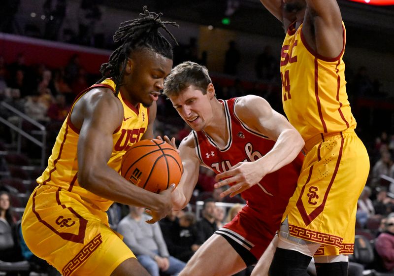 Feb 15, 2024; Los Angeles, California, USA; Southern California Trojans guard Isaiah Collier (left) steals the ball away from Utah Utes forward Ben Carlson (1) during the first half at Galen Center. Mandatory Credit: Alex Gallardo-USA TODAY Sports