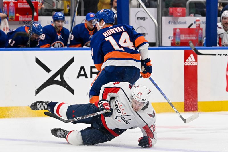 Dec 29, 2023; Elmont, New York, USA; Washington Capitals center Connor McMichael (24) and New York Islanders center Bo Horvat (14) collide during the second period at UBS Arena. Mandatory Credit: Dennis Schneidler-USA TODAY Sports