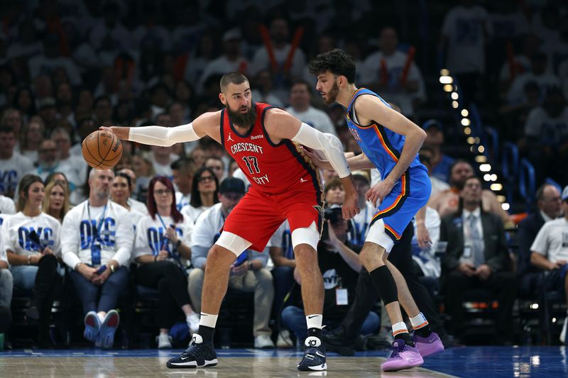 OKLAHOMA CITY, OKLAHOMA - APRIL 24:  Jonas Valanciunas #17 of the New Orleans Pelicans controls the ball as Chet Holmgren #7 of the Oklahoma City Thunder defends during the first half of game two of the first round of the NBA playoffs at Paycom Center on April 24, 2024 in Oklahoma City, Oklahoma. (Photo by Jamie Squire/Getty Images)