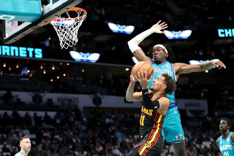 CHARLOTTE, NORTH CAROLINA - OCTOBER 25: Mark Williams #5 of the Charlotte Hornets defends a shot by Trae Young #11 of the Atlanta Hawks during the first half of a basketball game at Spectrum Center on October 25, 2023 in Charlotte, North Carolina. NOTE TO USER: User expressly acknowledges and agrees that, by downloading and or using this photograph, User is consenting to the terms and conditions of the Getty Images License Agreement. (Photo by David Jensen/Getty Images)