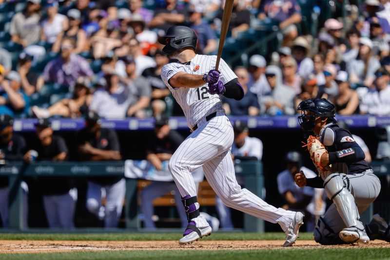 May 27, 2024; Denver, Colorado, USA; Colorado Rockies left fielder Sean Bouchard (12) hits an RBI in the fourth inning against the Cleveland Guardians at Coors Field. Mandatory Credit: Isaiah J. Downing-USA TODAY Sports