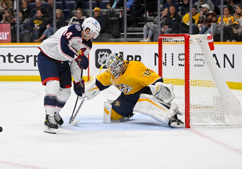 Jan 17, 2023; Nashville, Tennessee, USA;  Nashville Predators goaltender Kevin Lankinen (32) blocks the shot of Columbus Blue Jackets left wing Gustav Nyquist (14) during the second period at Bridgestone Arena. Mandatory Credit: Steve Roberts-USA TODAY Sports