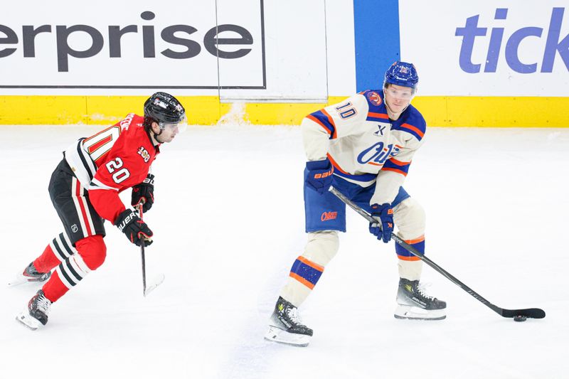 Jan 12, 2026; Chicago, Illinois, USA; Edmonton Oilers center Trent Frederic (10) looks to pass the puck against Chicago Blackhawks center Ryan Greene (20) during the second period at United Center. Mandatory Credit: Kamil Krzaczynski-Imagn Images