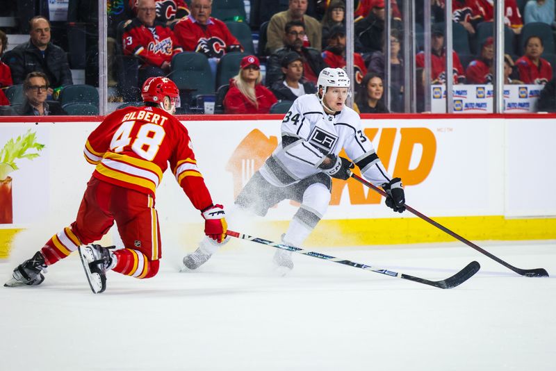 Mar 28, 2023; Calgary, Alberta, CAN; Los Angeles Kings right wing Arthur Kaliyev (34) controls the puck against Calgary Flames defenseman Dennis Gilbert (48) during the third period at Scotiabank Saddledome. Mandatory Credit: Sergei Belski-USA TODAY Sports