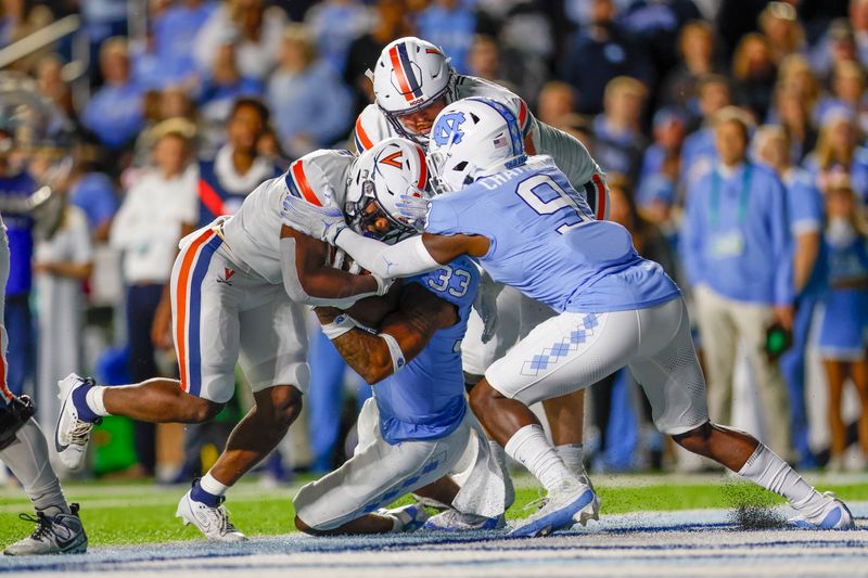 Oct 21, 2023; Chapel Hill, North Carolina, USA; Virginia Cavaliers running back Mike Hollins (7) rushes for a touchdown against North Carolina Tar Heels defensive back Armani Chatman (9) in the first half at Kenan Memorial Stadium. Mandatory Credit: Nell Redmond-USA TODAY Sports