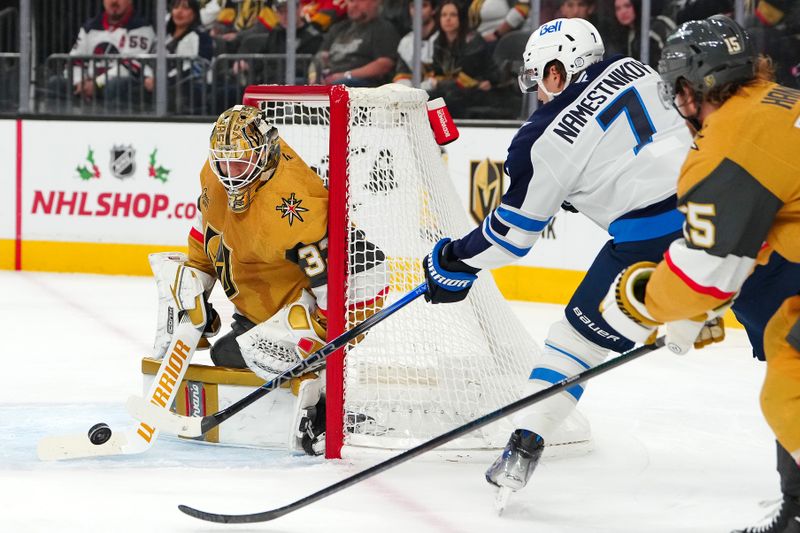 Nov 29, 2024; Las Vegas, Nevada, USA; Vegas Golden Knights goaltender Adin Hill (33) deflects a centering pass by Winnipeg Jets center Vladislav Namestnikov (7) during the first period at T-Mobile Arena. Mandatory Credit: Stephen R. Sylvanie-Imagn Images