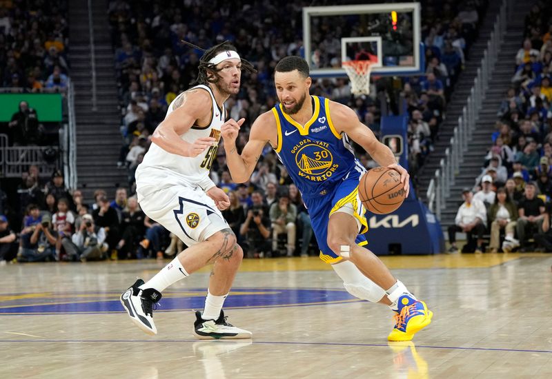 SAN FRANCISCO, CALIFORNIA - FEBRUARY 25: Stephen Curry #30 of the Golden State Warriors dribbling the ball is guarded by Aaron Gordon #50 of the Denver Nuggets during the third quarter of an NBA basketball game at Chase Center on February 25, 2024 in San Francisco, California. NOTE TO USER: User expressly acknowledges and agrees that, by downloading and or using this photograph, User is consenting to the terms and conditions of the Getty Images License Agreement. (Photo by Thearon W. Henderson/Getty Images)