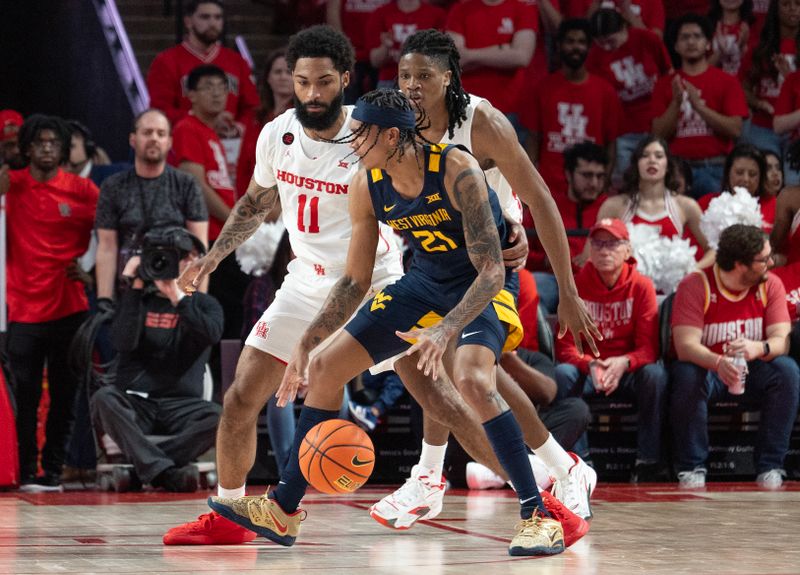 Jan 6, 2024; Houston, Texas, USA; West Virginia Mountaineers guard RaeQuan Battle (21) is guarded y Houston Cougars guard Damian Dunn (11) in the second half at Fertitta Center. Mandatory Credit: Thomas Shea-USA TODAY Sports