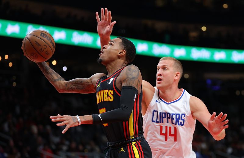 ATLANTA, GEORGIA - FEBRUARY 05:  Dejounte Murray #5 of the Atlanta Hawks drives against Mason Plumlee #44 of the LA Clippers during the first quarter at State Farm Arena on February 05, 2024 in Atlanta, Georgia.  NOTE TO USER: User expressly acknowledges and agrees that, by downloading and/or using this photograph, user is consenting to the terms and conditions of the Getty Images License Agreement.  (Photo by Kevin C. Cox/Getty Images)