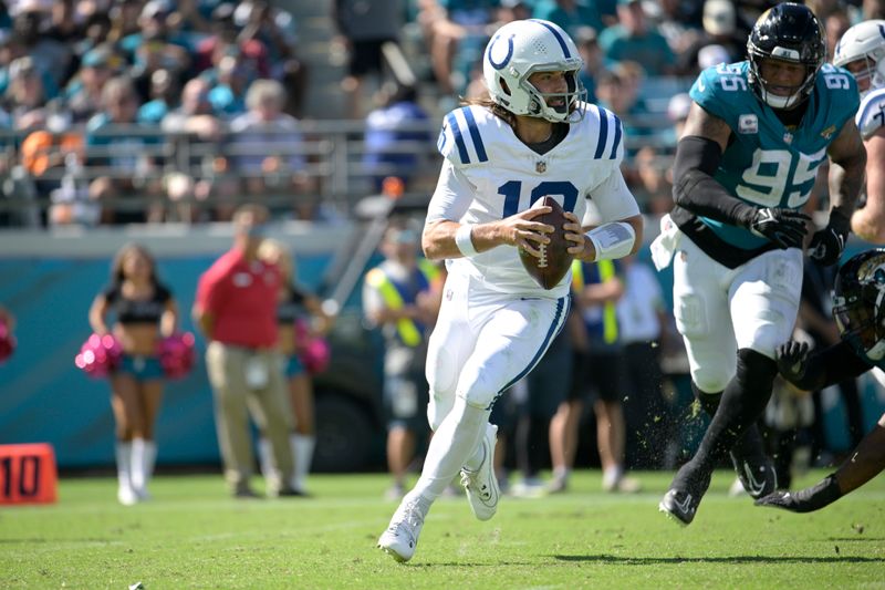 Indianapolis Colts quarterback Gardner Minshew (10) scrambles away from Jacksonville Jaguars defensive end Roy Robertson-Harris (95) during the second half of an NFL football game, Sunday, Oct. 15, 2023, in Jacksonville, Fla. (AP Photo/Phelan M. Ebenhack)