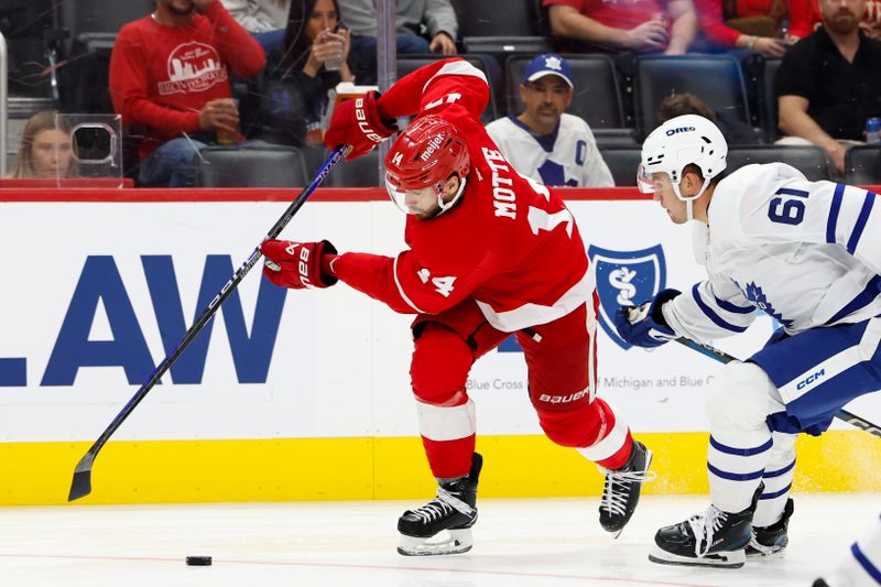 Oct 3, 2024; Detroit, Michigan, USA;  Detroit Red Wings center Tyler Motte (14) skates with the puck defended by Toronto Maple Leafs center Jacob Quillan (61) in the second period at Little Caesars Arena. Mandatory Credit: Rick Osentoski-Imagn Images