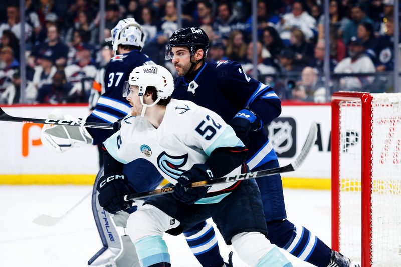 Apr 16, 2024; Winnipeg, Manitoba, CAN;  Seattle Kraken forward Tye Kartye (52) jostles for position with Winnipeg Jets defenseman Dylan DeMelo (2) during the first period at Canada Life Centre. Mandatory Credit: Terrence Lee-USA TODAY Sports