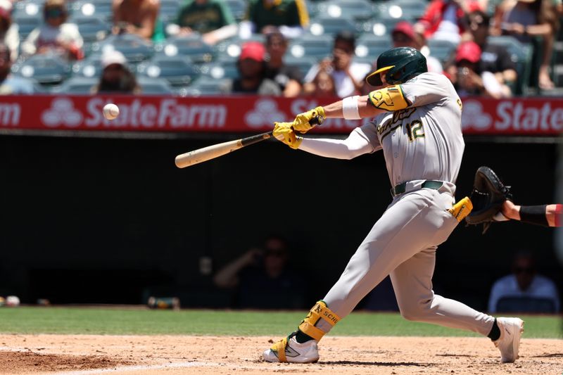 Jun 26, 2024; Anaheim, California, USA;  Oakland Athletics shortstop Max Schuemann (12) hits an RBI double against the Los Angeles Angels during the second inning at Angel Stadium. Mandatory Credit: Kiyoshi Mio-USA TODAY Sports