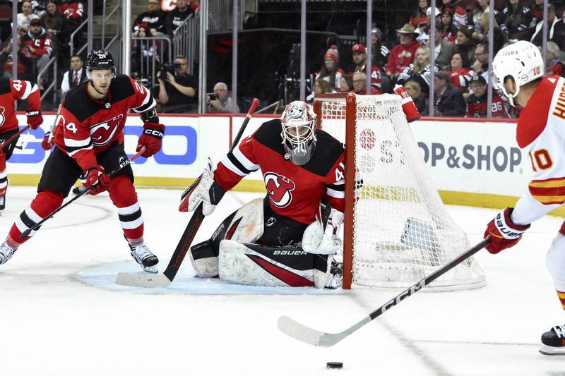 Feb 8, 2024; Newark, New Jersey, USA; New Jersey Devils goaltender Vitek Vanecek (41) tends net as Calgary Flames center Jonathan Huberdeau (10) lines up a shot during the first period at Prudential Center. Mandatory Credit: John Jones-USA TODAY Sports