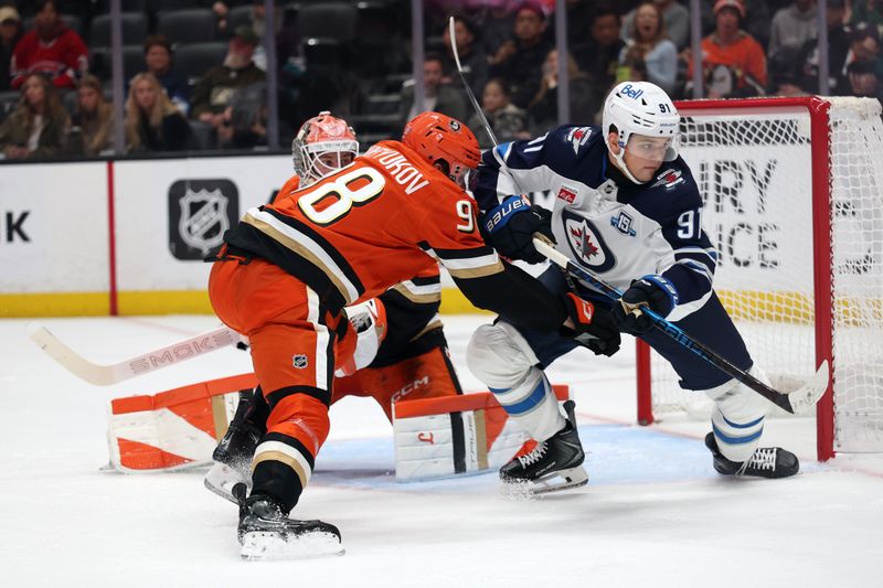 Nov 9, 2025; Anaheim, California, USA;  Winnipeg Jets center Cole Perfetti (91) fights for a position against Anaheim Ducks defenseman Pavel Mintyukov (98) during the first period at Honda Center. Mandatory Credit: Kiyoshi Mio-Imagn Images