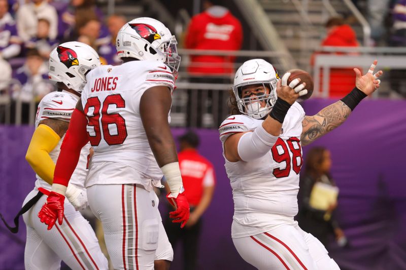 Arizona Cardinals defensive tackle Roy Lopez (98) celebrates with teammate defensive tackle Naquan Jones (96) after recovering a fumble by Minnesota Vikings running back Aaron Jones during the first half of an NFL football game Sunday, Dec. 1, 2024, in Minneapolis. (AP Photo/Bruce Kluckhohn)