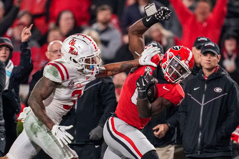Nov 11, 2023; Athens, Georgia, USA; A Georgia Bulldogs running back Roderick Robinson II (0) tries to stay in bounds against Mississippi Rebels safety Daijahn Anthony (3) during the second half at Sanford Stadium. Mandatory Credit: Dale Zanine-USA TODAY Sports