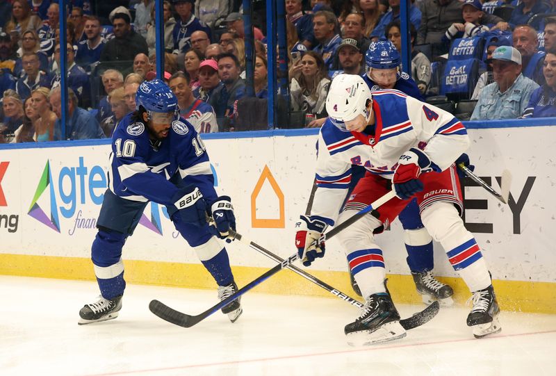 Mar 14, 2024; Tampa, Florida, USA; Tampa Bay Lightning left wing Anthony Duclair (10), center Steven Stamkos (91) and New York Rangers defenseman Braden Schneider (4) fight to control the puck during the first period at Amalie Arena. Mandatory Credit: Kim Klement Neitzel-USA TODAY Sports