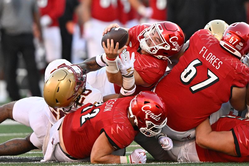 Sep 23, 2023; Louisville, Kentucky, USA;  Louisville Cardinals quarterback Brock Domann (19) stretches against Boston College Eagles defensive back Carter Davis (28) to make a first down during the second half at L&N Federal Credit Union Stadium. Louisville defeated Boston College 56-28. Mandatory Credit: Jamie Rhodes-USA TODAY Sports