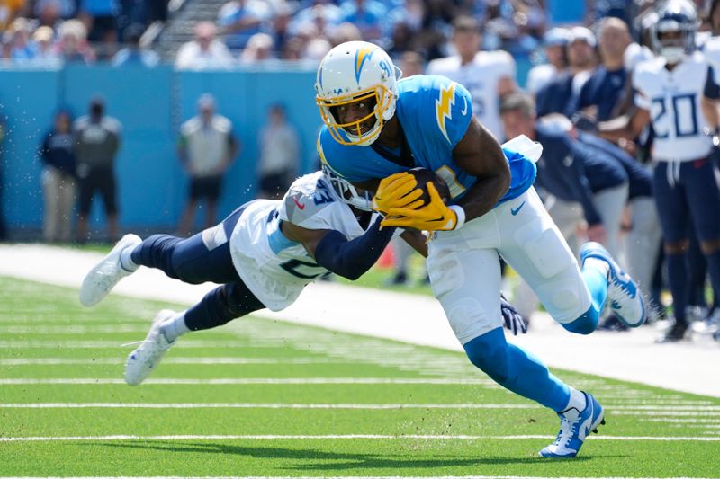 Los Angeles Chargers wide receiver Mike Williams, right, makes a catch as Tennessee Titans cornerback Tre Avery tackles him during the first half of an NFL football game Sunday, Sept. 17, 2023, in Nashville, Tenn. (AP Photo/George Walker IV)