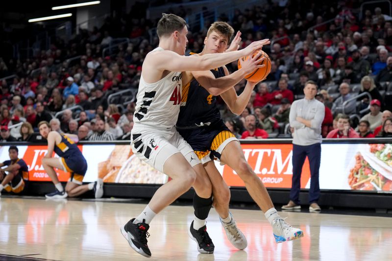 Dec 19, 2023; Cincinnati, Ohio, USA; Merrimack Warriors guard Jordan Derkack (4) drives to the basket against Cincinnati Bearcats guard Simas Lukosius (41) in the second half at Fifth Third Arena. Mandatory Credit: Aaron Doster-USA TODAY Sports