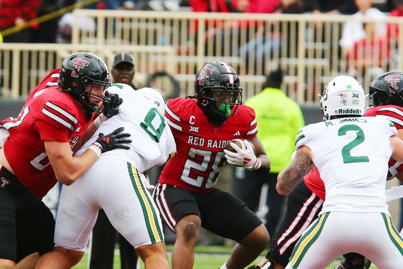 Oct 19, 2024; Lubbock, Texas, USA;  Texas Tech Red Raiders running back Tahj Brooks (28) runs the ball against Baylor Bears defensive back Matt Jones (2) in the first half at Jones AT&T Stadium and Cody Campbell Field. Mandatory Credit: Michael C. Johnson-Imagn Images